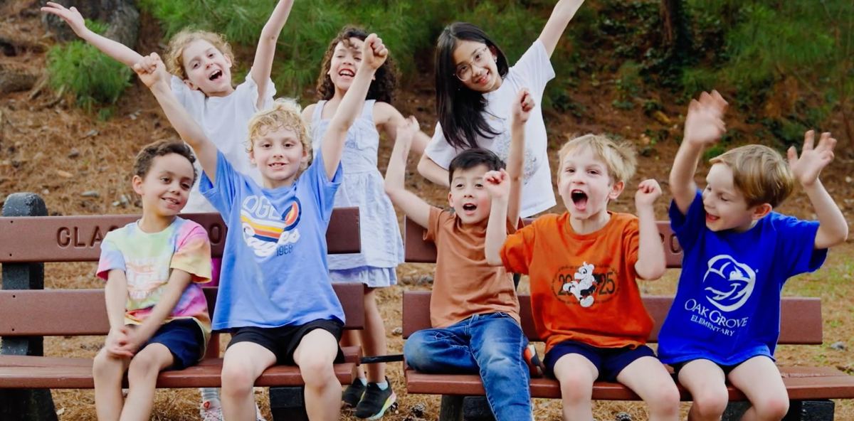 Oak Grove Elementary students cheering together on a bench
