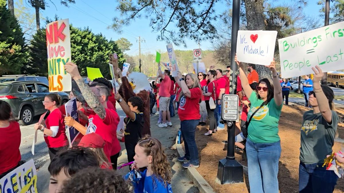 Parents and community members rally with signs to save DeKalb County schools